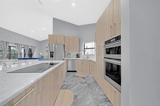 5260 NW 74th Ter, Lauderhill, FL 33319 - kitchen with light brown cabinetry, modern cabinets, appliances with stainless steel finishes, light marble finish floors, and light stone countertops