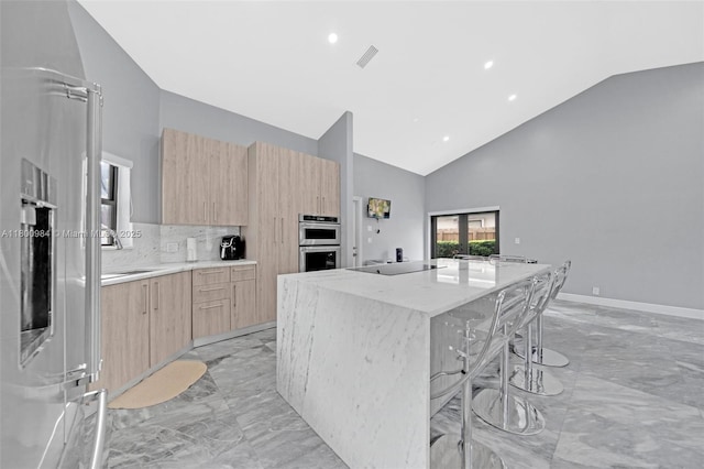 5260 NW 74th Ter, Lauderhill, FL 33319 - kitchen with light brown cabinets, light marble finish floors, modern cabinets, appliances with stainless steel finishes, and a spacious island