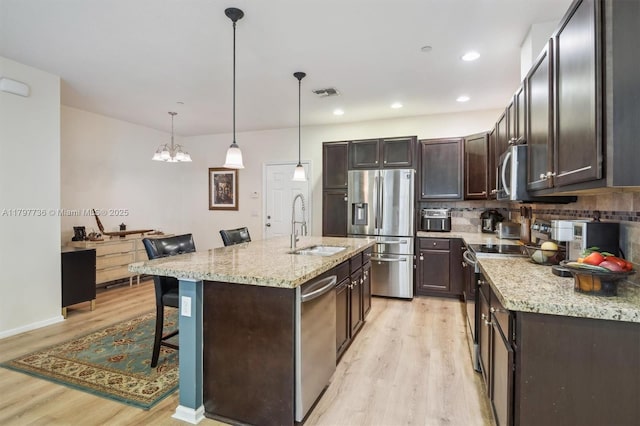 4346 Cascada Cir, Cooper City, FL 33024 - kitchen featuring stainless steel appliances, a sink, light wood-type flooring, a kitchen bar, and recessed lighting