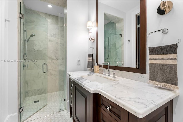 bathroom with a marble finish shower, recessed lighting, and vanity