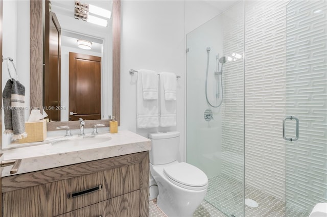 bathroom with a shower stall, toilet, vanity, and tile patterned floors