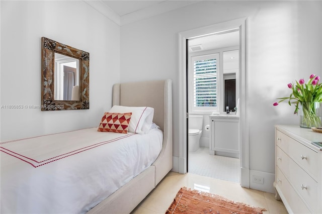 bedroom featuring connected bathroom and light tile patterned flooring