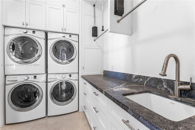 laundry area with stacked washer / drying machine, cabinet space, and washing machine and dryer