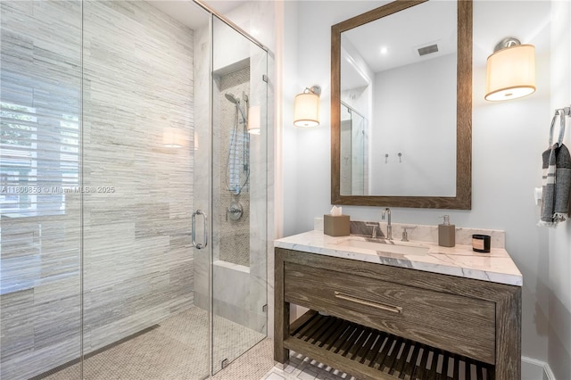 bathroom with a shower stall and vanity