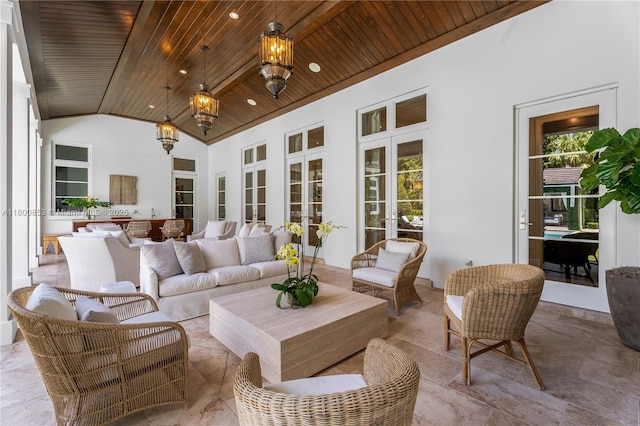 sunroom / solarium with a chandelier, lofted ceiling, and french doors
