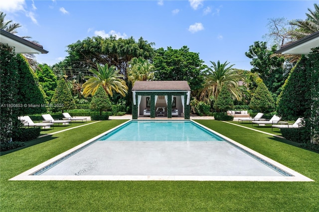 outdoor pool with a patio area, an exterior structure, an outdoor living space, an outbuilding, and a lawn