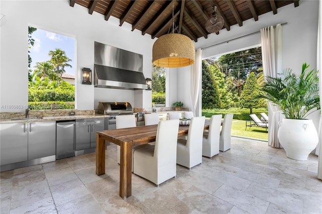 view of patio with exterior kitchen, outdoor dining area, and a sink