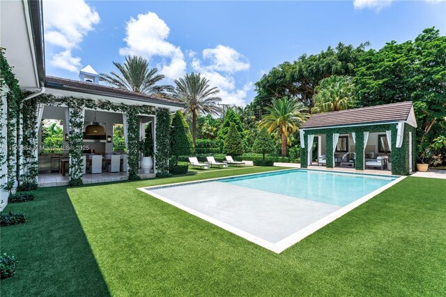 outdoor pool with area for grilling, an outdoor hangout area, a patio area, and a yard