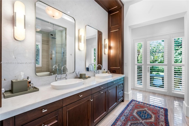full bath with a shower stall, plenty of natural light, and double vanity
