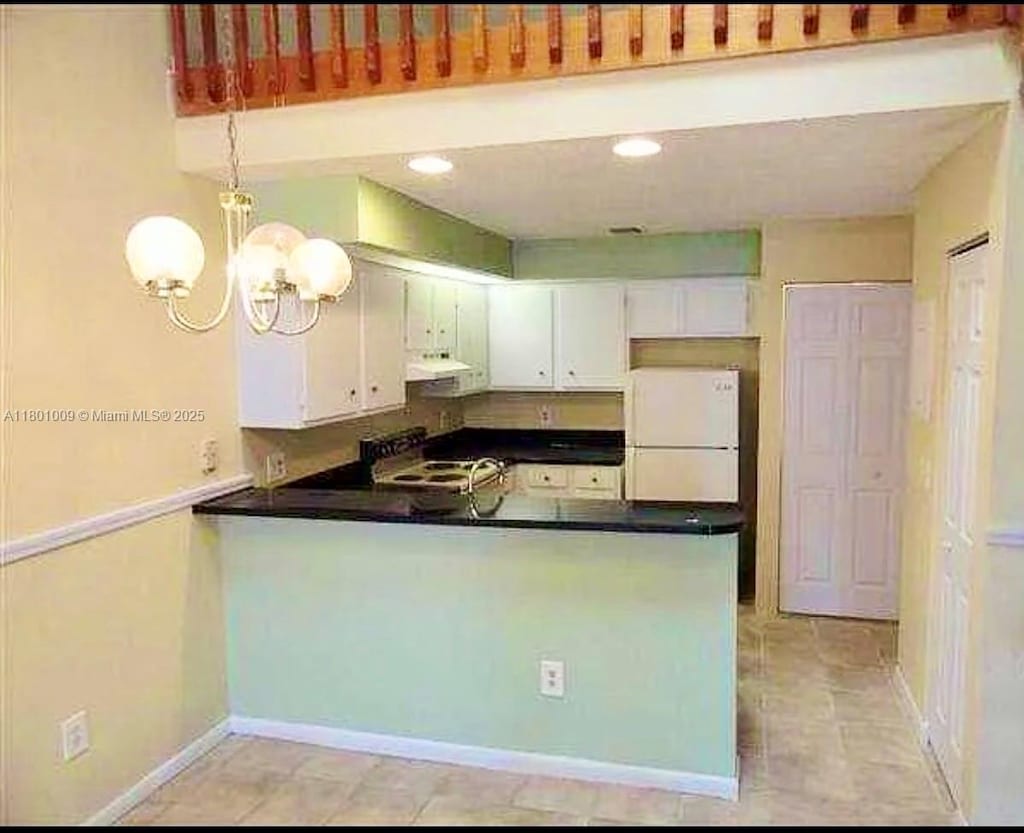 2058 Winners Cir, North Lauderdale, FL 33068 - kitchen featuring freestanding refrigerator, under cabinet range hood, a peninsula, dark countertops, and white cabinetry