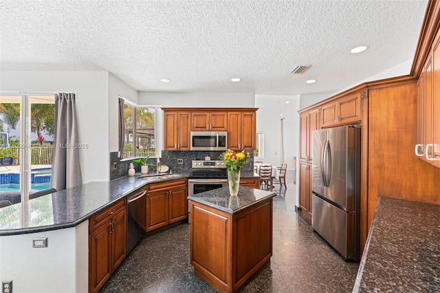 1106 NW 180th Ave, Pembroke Pines, FL 33029 - kitchen with stainless steel appliances, a center island, a sink, decorative backsplash, and a textured ceiling