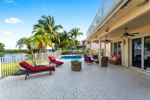 1106 NW 180th Ave, Pembroke Pines, FL 33029 - view of swimming pool featuring an outdoor living space with a fire pit, a water view, ceiling fan, a fenced backyard, and a patio