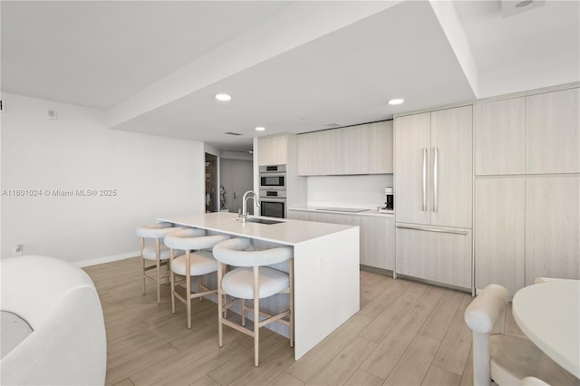 488 NE 18th St Unit 715, Miami, FL 33132 - kitchen with modern cabinets, black electric stovetop, double oven, an island with sink, and light wood-type flooring