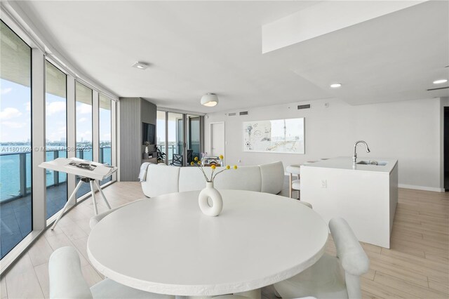 488 NE 18th St Unit 715, Miami, FL 33132 - dining area with light wood-style floors, a water view, a wall of windows, and recessed lighting