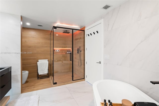 488 NE 18th St Unit 715, Miami, FL 33132 - full bath with a soaking tub, a shower stall, tile walls, marble finish floors, and vanity