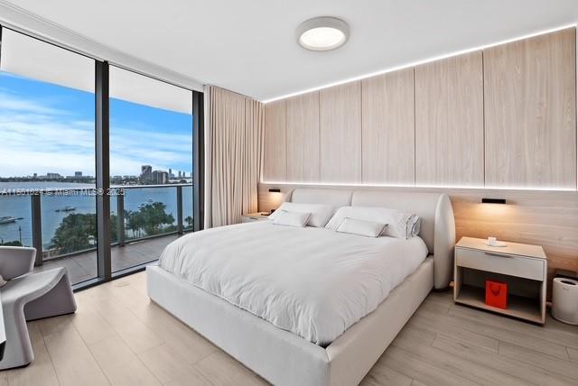 488 NE 18th St Unit 715, Miami, FL 33132 - bedroom featuring expansive windows, light wood finished floors, and access to outside