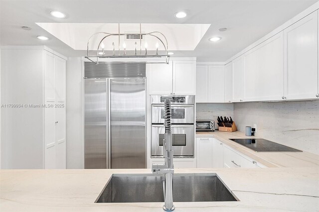 9401 Collins Ave Unit 505, Surfside, FL 33154 - kitchen featuring appliances with stainless steel finishes, recessed lighting, white cabinetry, tasteful backsplash, and light stone countertops
