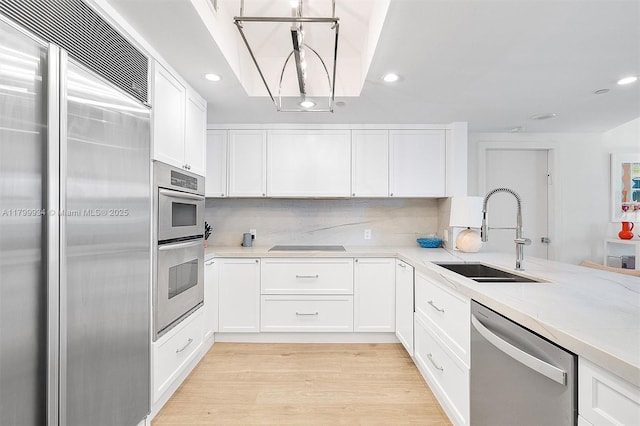 9401 Collins Ave Unit 505, Surfside, FL 33154 - kitchen featuring stainless steel appliances, a sink, white cabinets, recessed lighting, and light wood finished floors