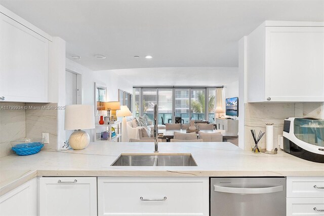 9401 Collins Ave Unit 505, Surfside, FL 33154 - kitchen featuring dishwasher, backsplash, white cabinets, light countertops, and a sink