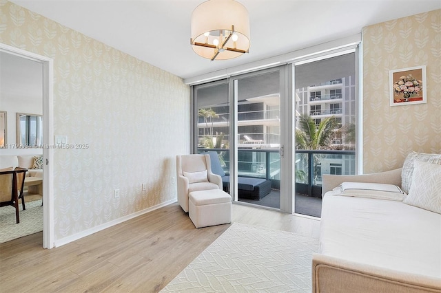 9401 Collins Ave Unit 505, Surfside, FL 33154 - sitting room with wallpapered walls, light wood-style flooring, floor to ceiling windows, a chandelier, and baseboards