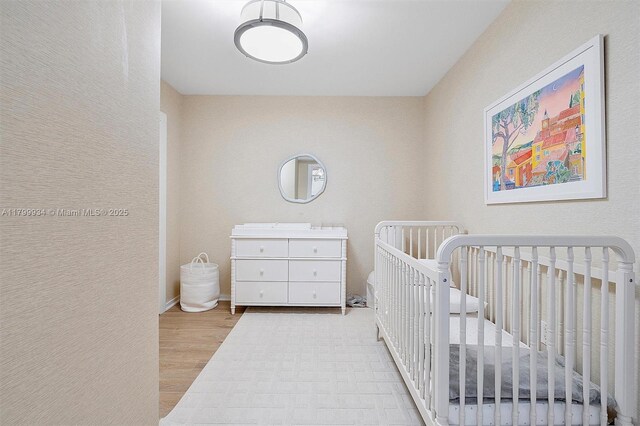 9401 Collins Ave Unit 505, Surfside, FL 33154 - bedroom featuring wood finished floors and a crib