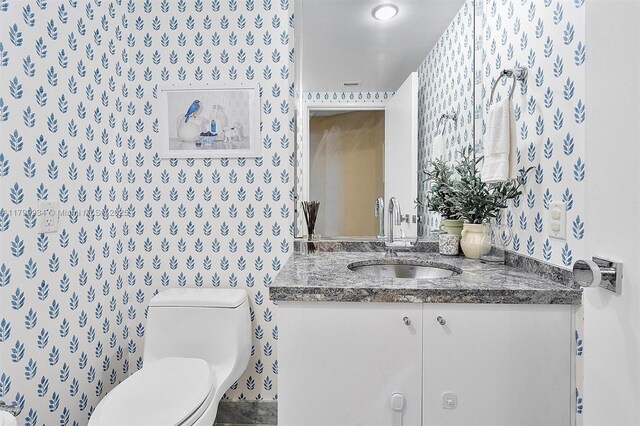 9401 Collins Ave Unit 505, Surfside, FL 33154 - bathroom featuring toilet, vanity, and wallpapered walls