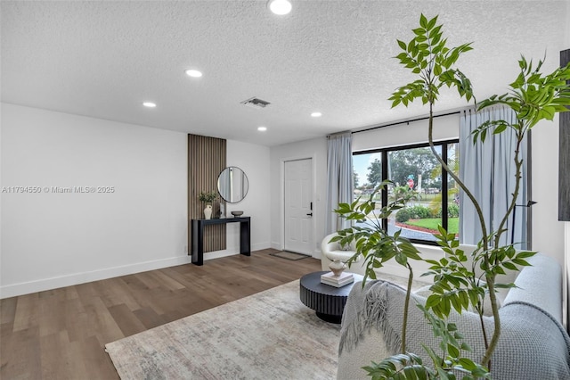sitting room featuring wood finished floors, recessed lighting, a textured ceiling, and baseboards
