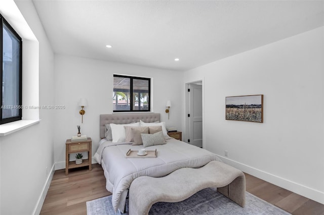 bedroom with light wood-style floors, baseboards, and recessed lighting