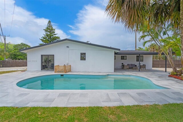 view of pool with outdoor lounge area, fence, and a patio area