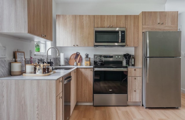 1153 NE 158th St, North Miami Beach, FL 33162 - kitchen with appliances with stainless steel finishes, light countertops, a sink, light wood-style flooring, and light brown cabinetry