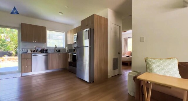 1153 NE 158th St, North Miami Beach, FL 33162 - kitchen featuring appliances with stainless steel finishes, modern cabinets, wood finished floors, a sink, and brown cabinetry