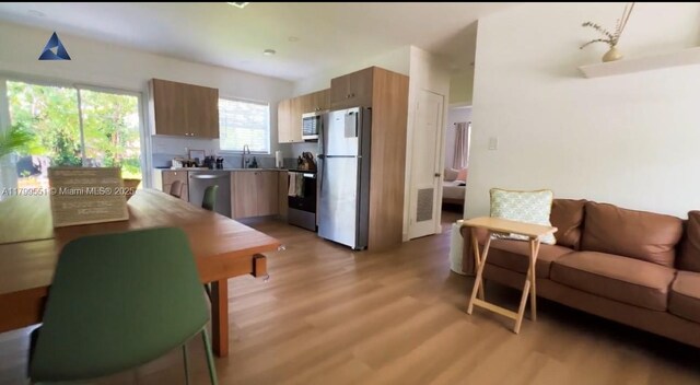 1153 NE 158th St, North Miami Beach, FL 33162 - kitchen with freestanding refrigerator, electric range oven, light wood-style flooring, a sink, and modern cabinets