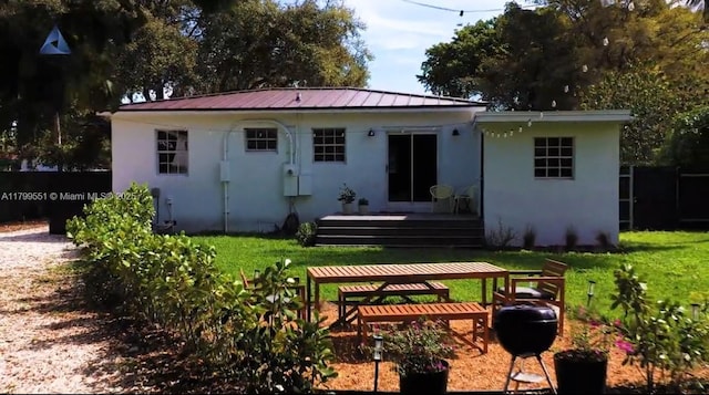 1153 NE 158th St, North Miami Beach, FL 33162 - rear view of house with stucco siding, a yard, and a deck