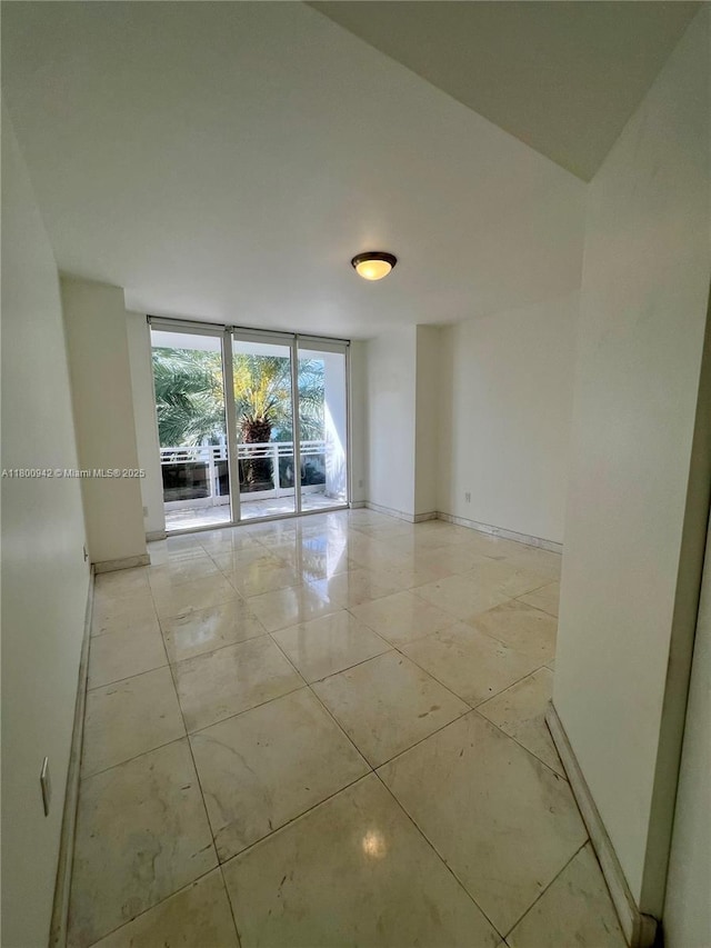 901 Brickell Key Blvd Unit 603, Miami, FL 33131 - empty room with floor to ceiling windows, baseboards, and light tile patterned flooring