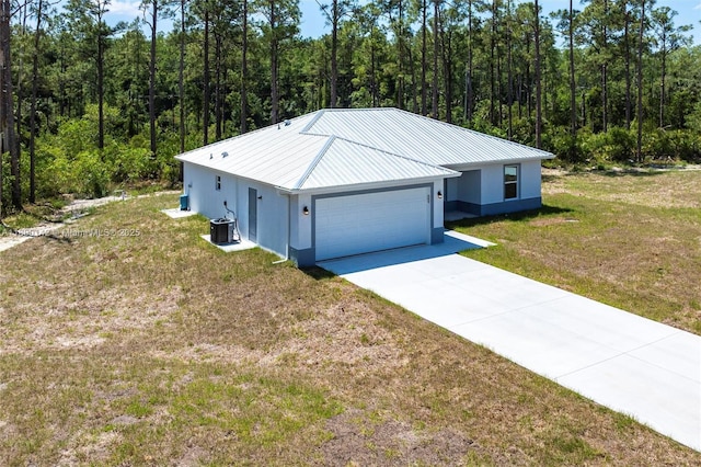 2004 Rosa Ct, Lehigh Acres, FL 33972 - view of front facade with stucco siding, a front lawn, a forest view, metal roof, and an attached garage