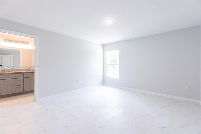 2004 Rosa Ct, Lehigh Acres, FL 33972 - unfurnished bedroom with light marble finish floors, ensuite bath, baseboards, and a sink