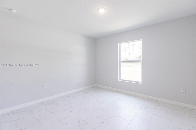 2004 Rosa Ct, Lehigh Acres, FL 33972 - unfurnished room with light marble finish floors, a smoke detector, and baseboards