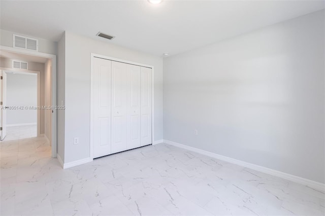 2004 Rosa Ct, Lehigh Acres, FL 33972 - unfurnished bedroom featuring light marble finish floors, baseboards, and a closet