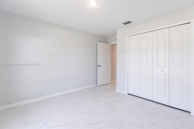 2004 Rosa Ct, Lehigh Acres, FL 33972 - unfurnished bedroom with light marble finish flooring, baseboards, and a closet