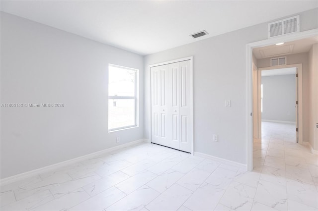 2004 Rosa Ct, Lehigh Acres, FL 33972 - unfurnished bedroom featuring light marble finish flooring, a closet, and baseboards