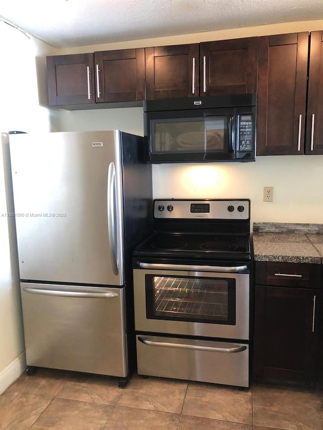 492 NW 165th St Rd Unit C514, Miami, FL 33169 - kitchen featuring stainless steel appliances, dark brown cabinetry, dark countertops, light tile patterned floors, and baseboards