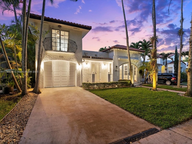1125 Asturia Ave, Coral Gables, FL 33134 - mediterranean / spanish house featuring french doors, a balcony, a tile roof, stucco siding, and concrete driveway