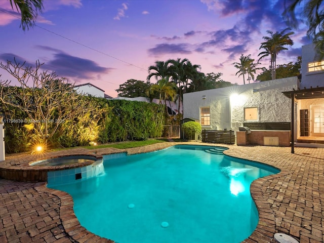 1125 Asturia Ave, Coral Gables, FL 33134 - pool at dusk featuring exterior kitchen, a patio, fence, and a pool with connected hot tub