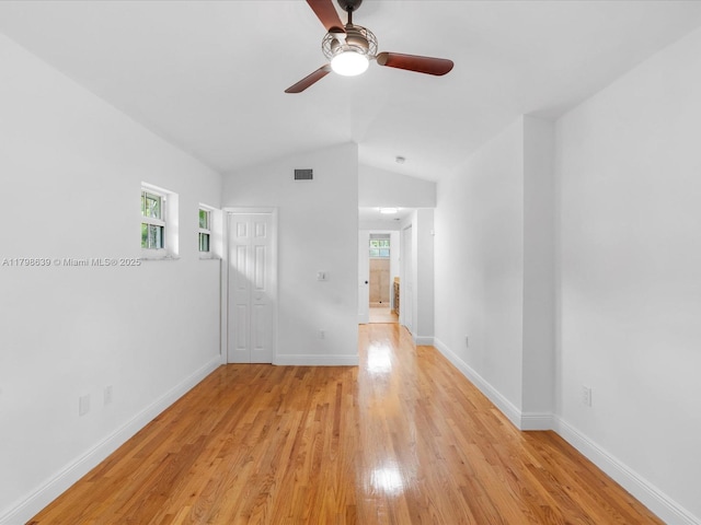 1125 Asturia Ave, Coral Gables, FL 33134 - empty room with plenty of natural light, ceiling fan, light wood-style floors, vaulted ceiling, and baseboards