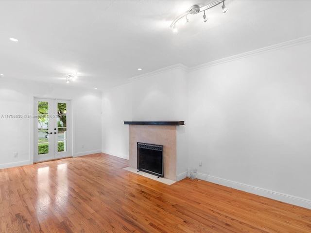 1125 Asturia Ave, Coral Gables, FL 33134 - unfurnished living room featuring a fireplace with flush hearth, french doors, crown molding, wood finished floors, and baseboards