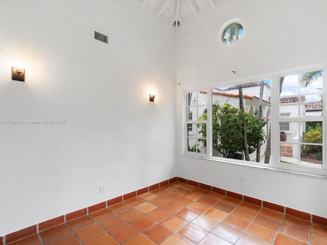 1125 Asturia Ave, Coral Gables, FL 33134 - empty room featuring baseboards, a high ceiling, and tile patterned flooring