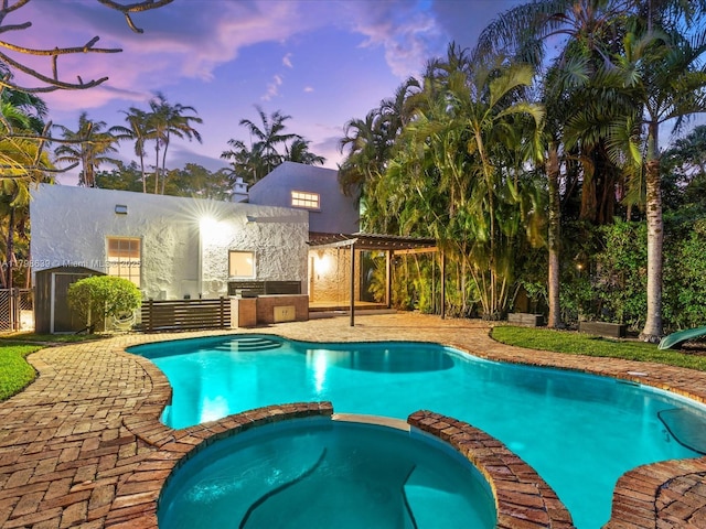 1125 Asturia Ave, Coral Gables, FL 33134 - pool at dusk featuring a pergola, a pool with connected hot tub, a patio area, and fence