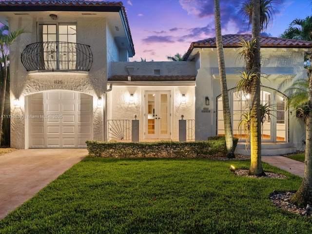 1125 Asturia Ave, Coral Gables, FL 33134 - mediterranean / spanish-style home with a balcony, a tile roof, stucco siding, a front lawn, and driveway