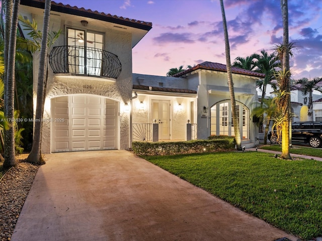 1125 Asturia Ave, Coral Gables, FL 33134 - mediterranean / spanish house featuring french doors, concrete driveway, stucco siding, a yard, and a tiled roof