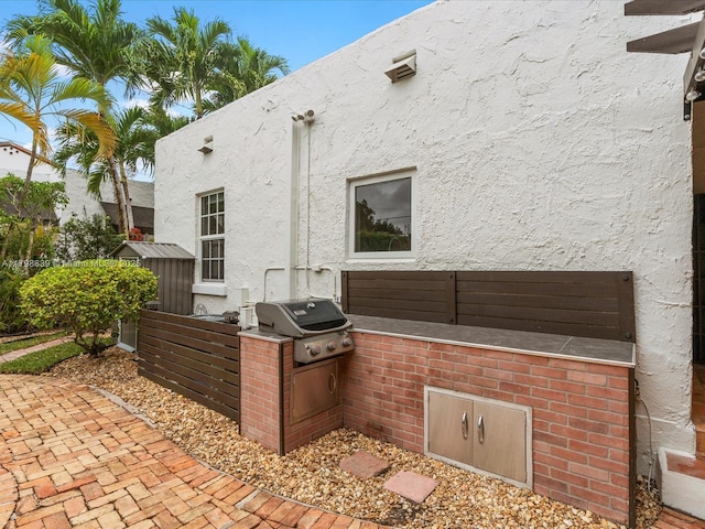 1125 Asturia Ave, Coral Gables, FL 33134 - rear view of property featuring exterior kitchen and stucco siding